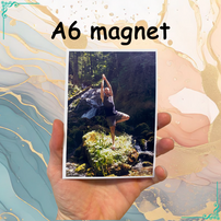 Aimant A6 avec cadre affiché dans une main. La photo montre une personne en posture de yoga dans un cadre naturel, entourée de verdure et d'une cascade. Texte au-dessus : "A6 magnet". Idéal pour personnaliser vos souvenirs.
