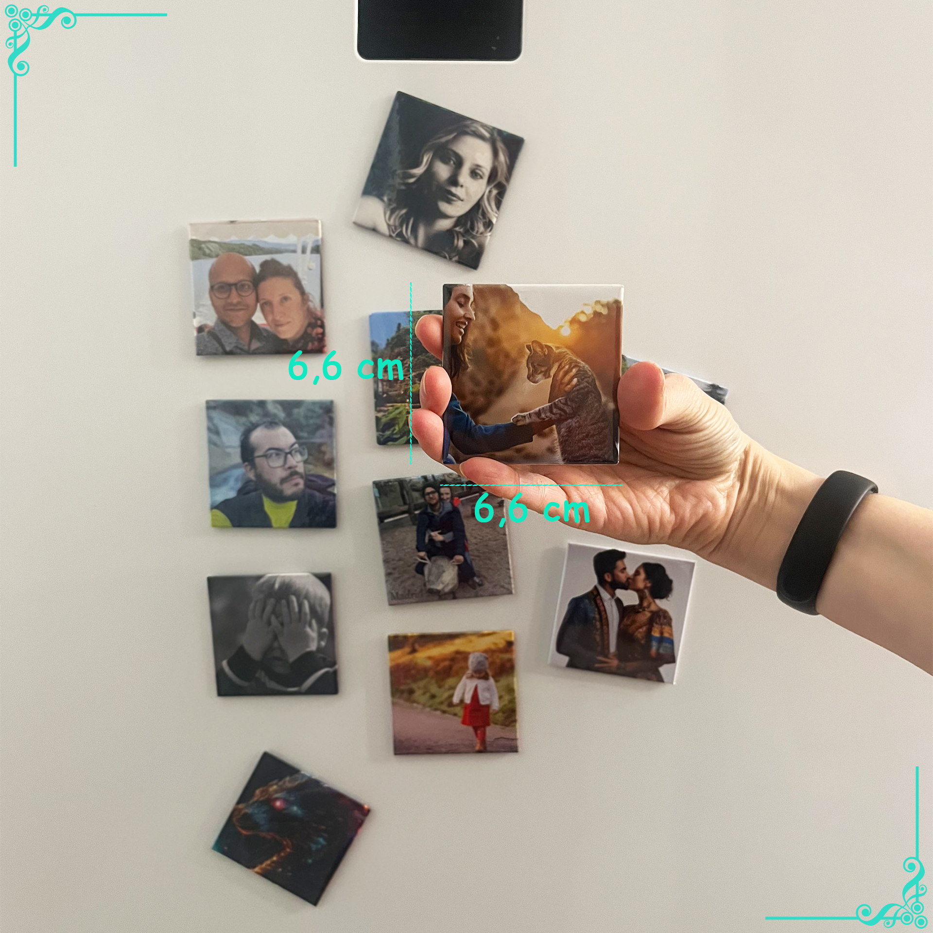 Une main de femme tient un petit carreau photo carré avec une image d'un couple enlacé, mesurant 6,6 cm de côté. Le carreau est tenu devant un mur blanc où d'autres carreaux photo similaires sont magnétiquement fixés. Ces carreaux montrent diverses photos de personnes, y compris des portraits et des photos de groupe. La main porte un bracelet noir et le mur est décoré de motifs d'angle décoratifs bleus et verts.